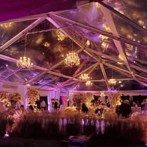 Interior of a clear top tent looking up through the roof panels at the evening sky