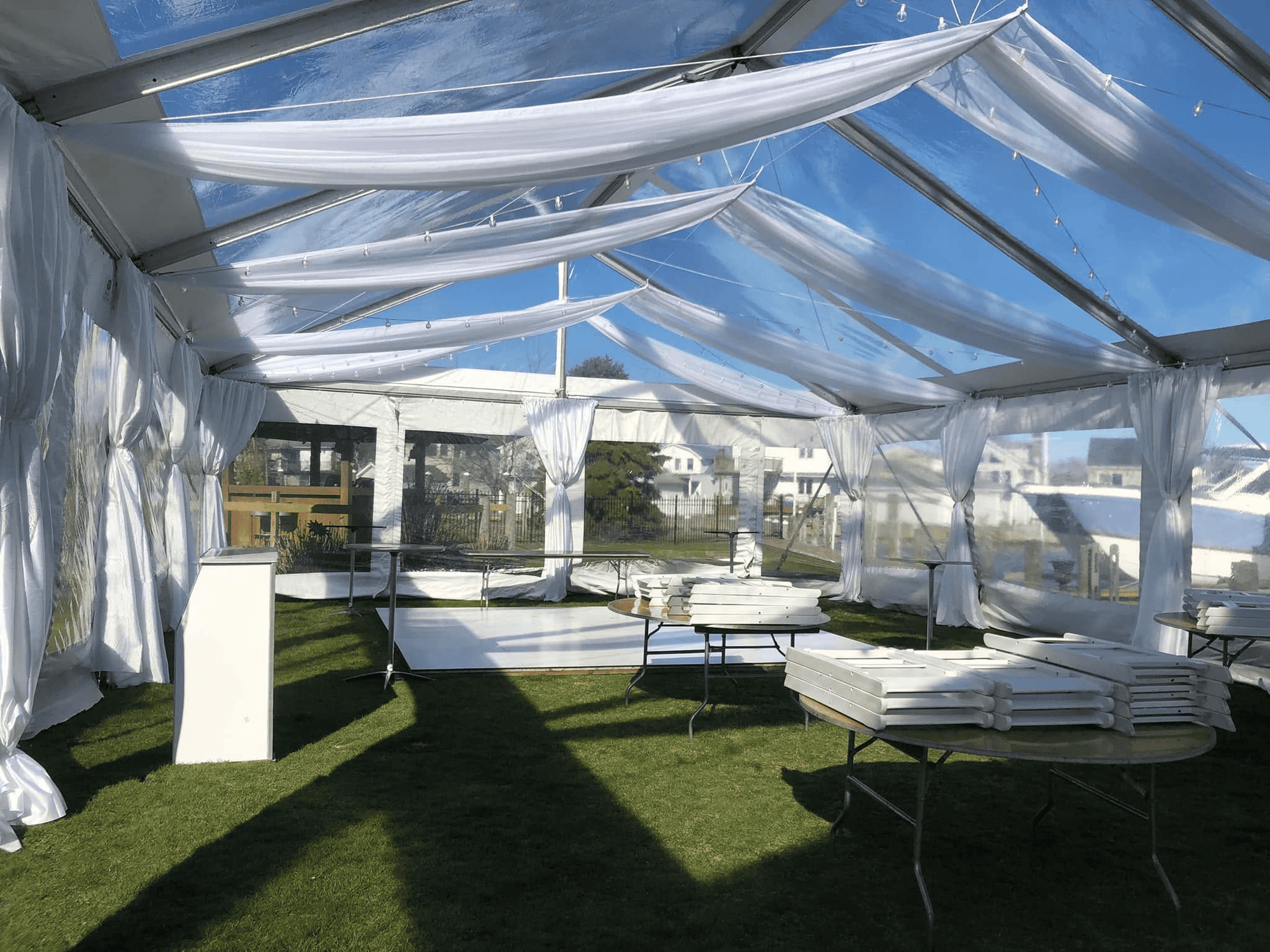 Clear top tent frame and transparent panels seen from outside against a tree line