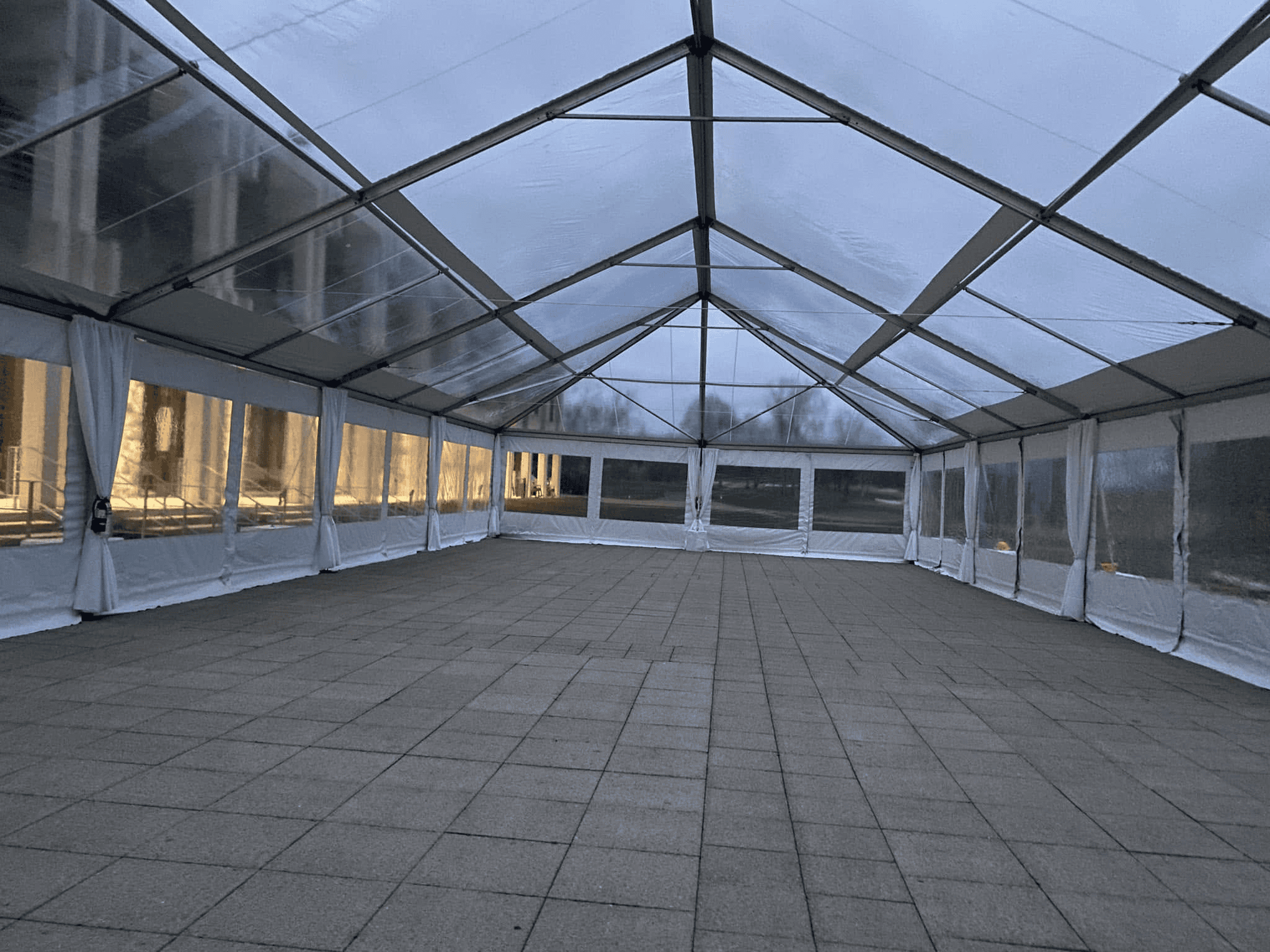 String lighting running along the frame lines inside a clear top tent after dark