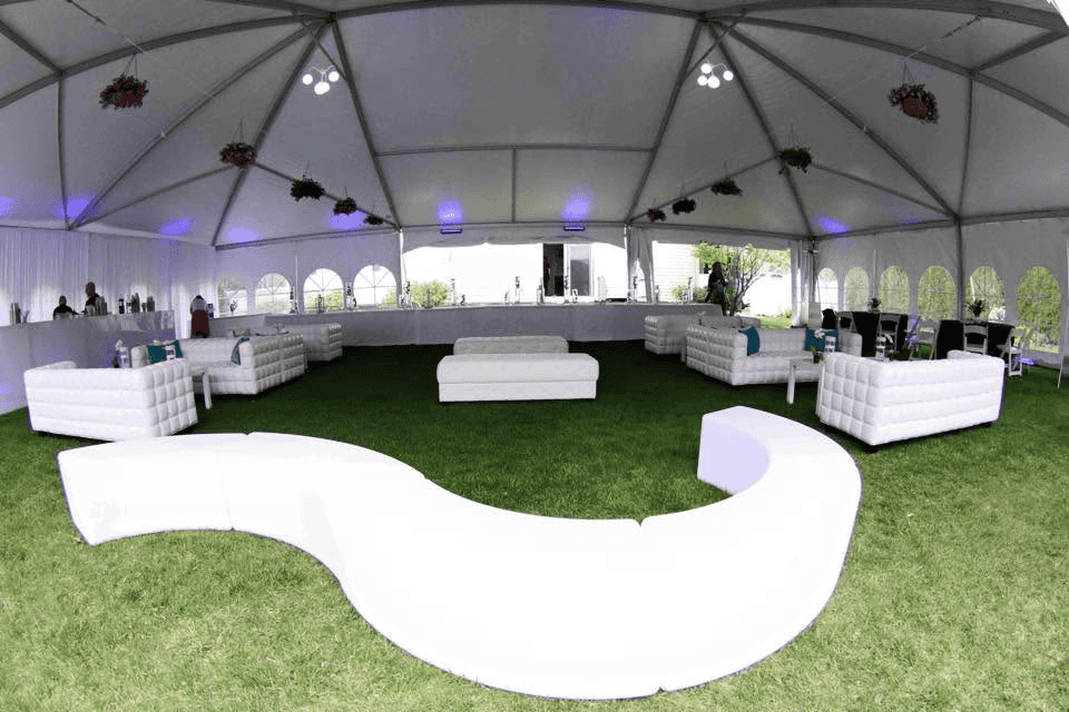 Wide span tent with solid walls fitted along the long sides for a large event