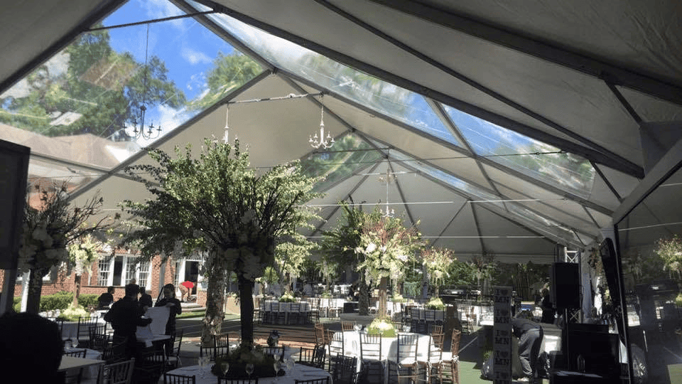 Wide clearspan tent lit at night with the full floor open beneath the roof