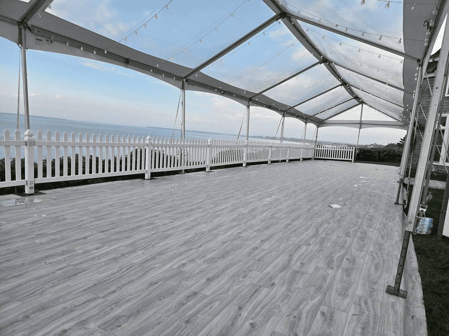 Tent covering a roof deck with flooring laid over the existing surface