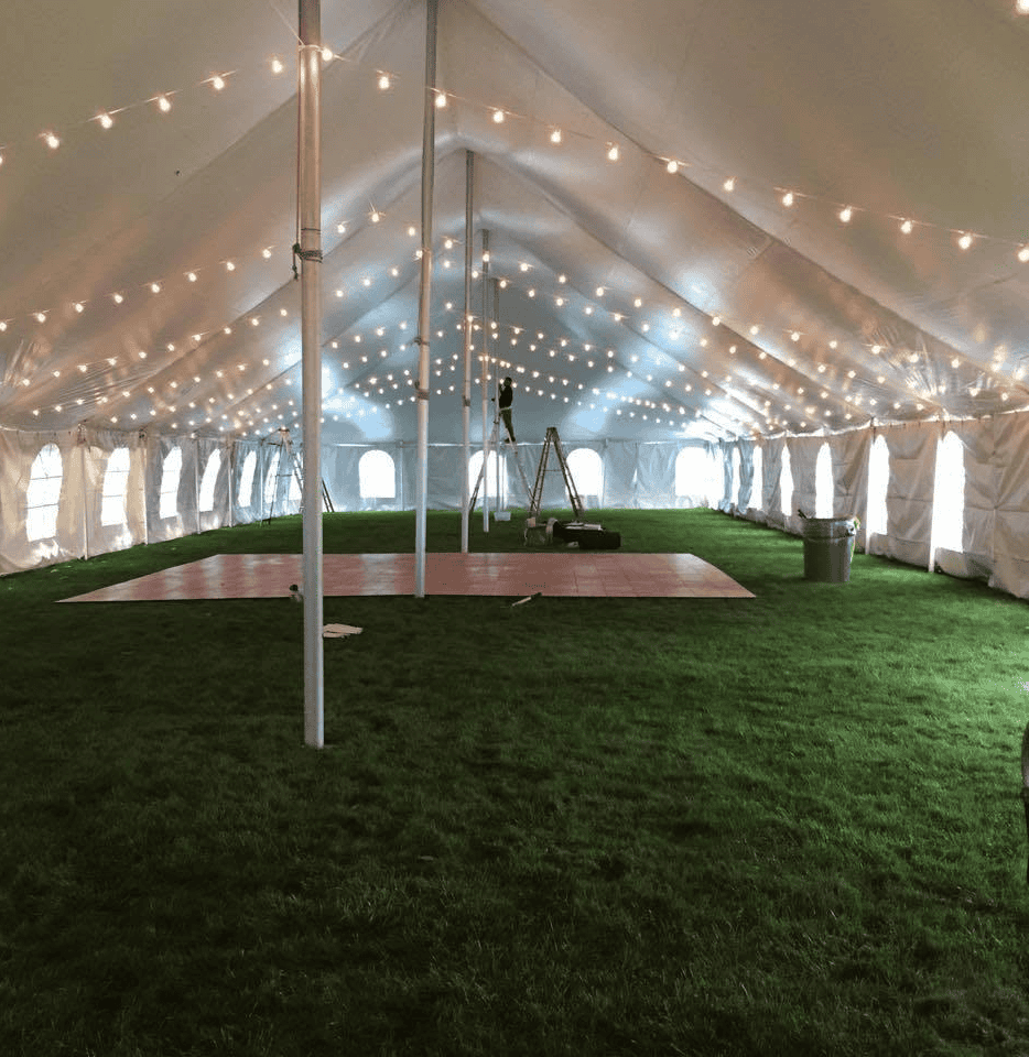 Rope and pole tent open on all sides over a daytime reception